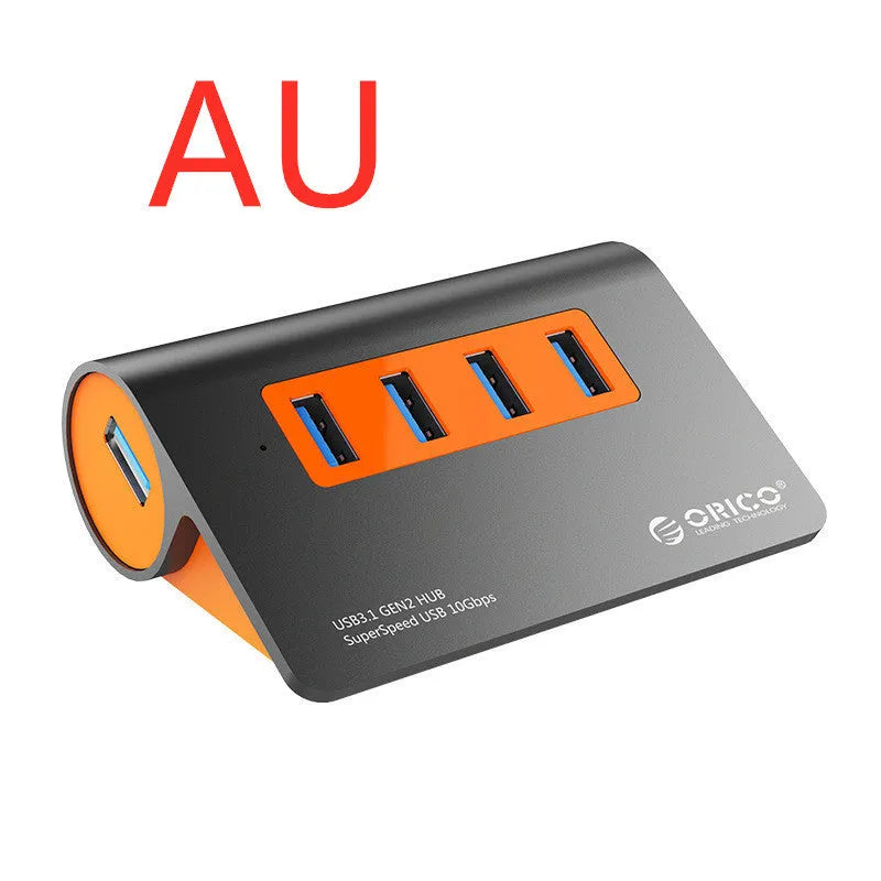 Dark grey and orange aluminium USB-C hub with four USB 3.1 ports, a DC power input, and a detachable cable.