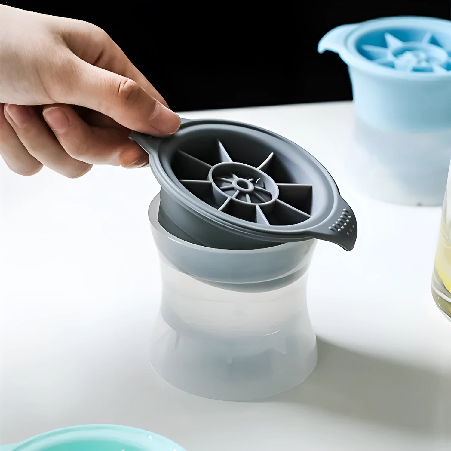 Silicone ice tray showing hockey puck shaped moulds alongside pentagon and spherical designs in light blue colour