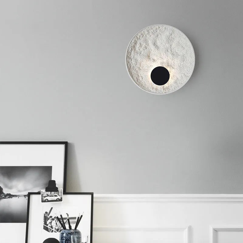 White modern iron wall lamp mounted on a wall, shown in two available sizes.