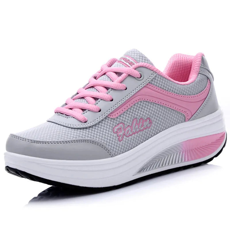 A pair of women's grey powder travel sports shoes with a mid-height heel on a white background.