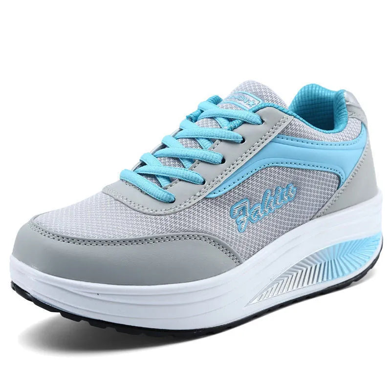 A pair of women's grey powder travel sports shoes with a mid-height heel on a white background.