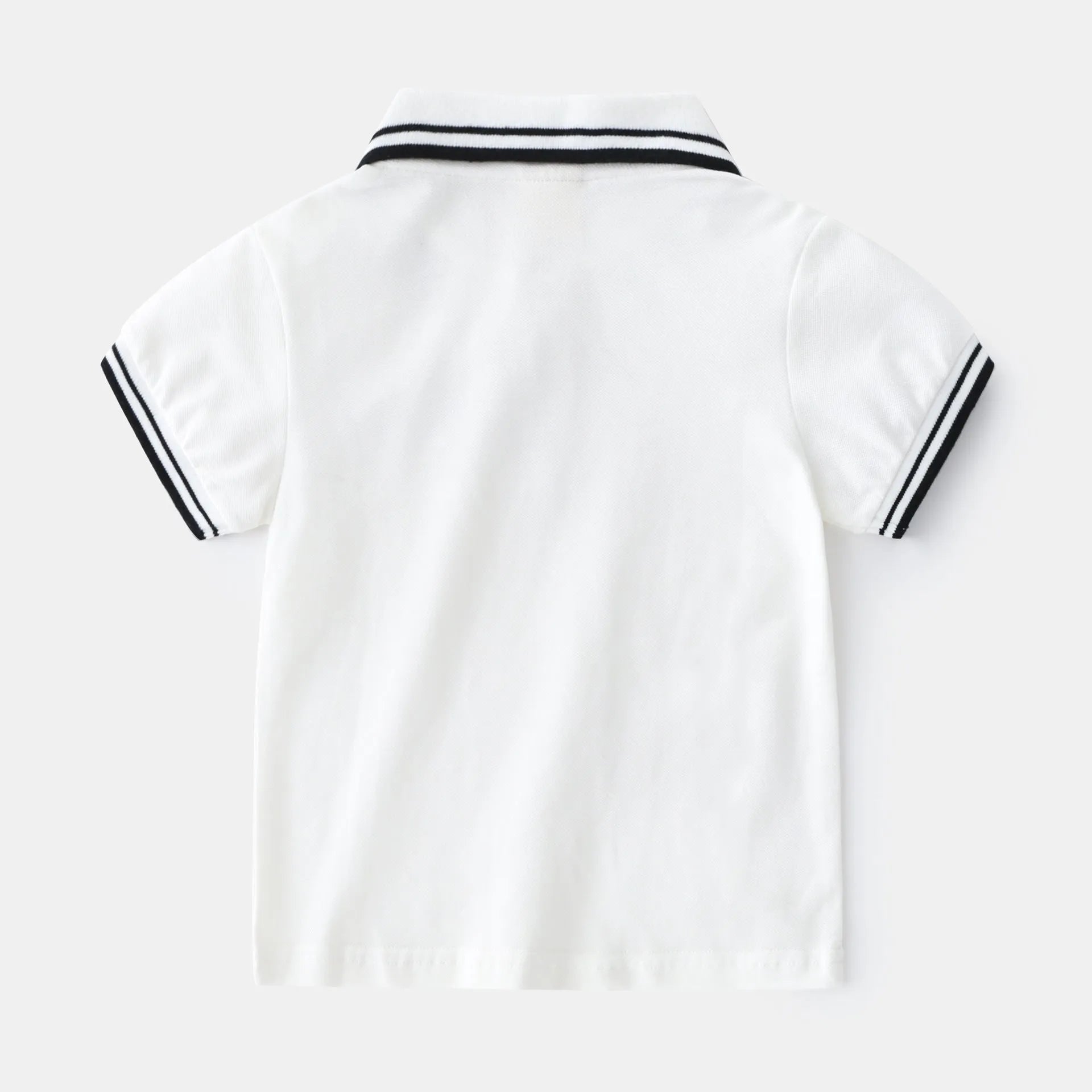 Boys plain cotton polo shirt in white or black with short sleeves and round neck.