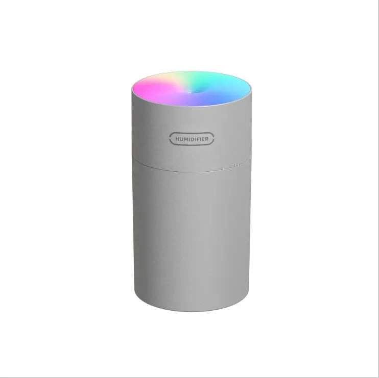 Pink USB portable humidifier with 300ml water tank on wooden desk surface