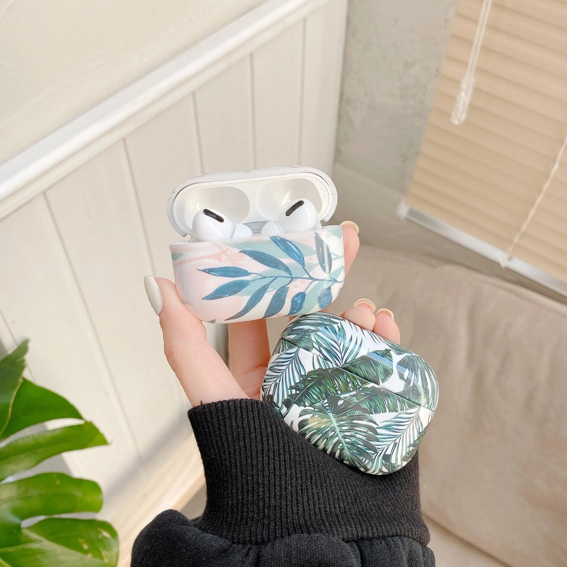 Blue and green banana leaves pattern AirPods protective case made from soft TPU material.