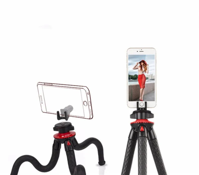 Black tripod octopus portable stand with flexible rubber legs, remote control, on a table with an iPhone