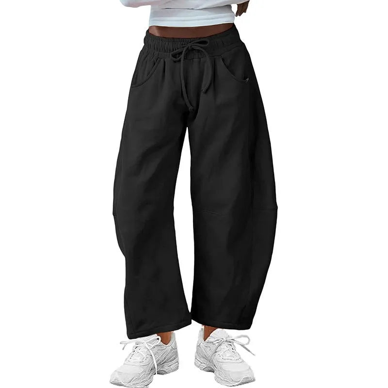 Women's loose grey cropped sweatpants with drawstring waist and side pockets on a hanger.