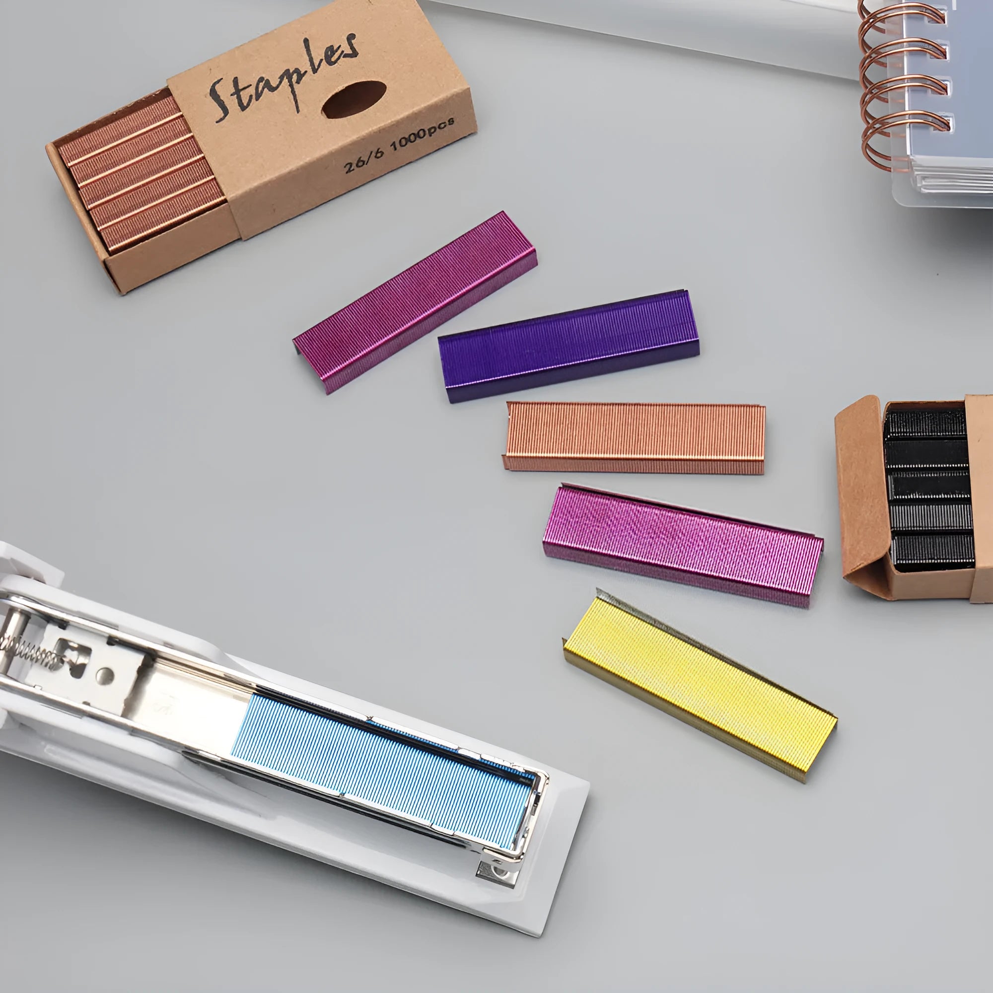 A box of 1000 metal office staples in choices of black, purple, rose gold, or rose red colour.