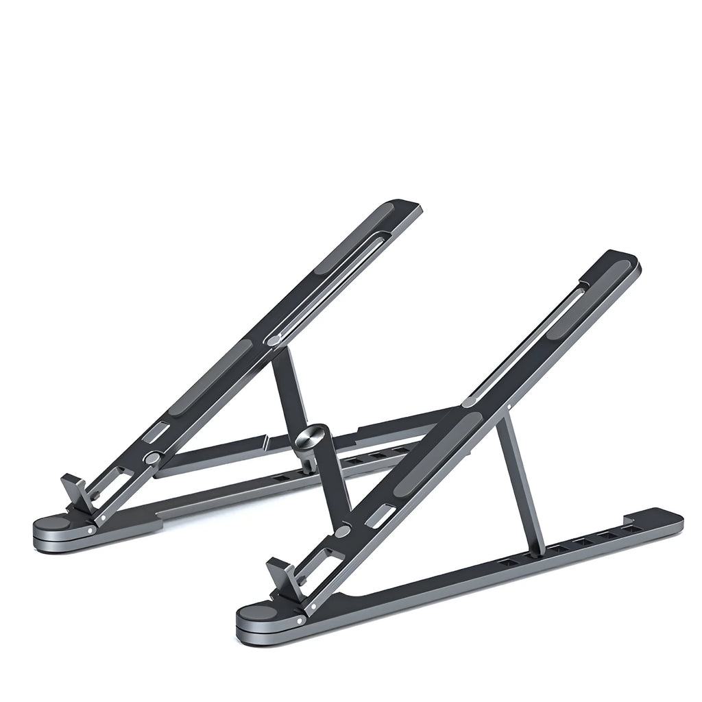 A folded silver aluminium laptop stand next to an open laptop, showing its thin profile and adjustable angle mechanism.