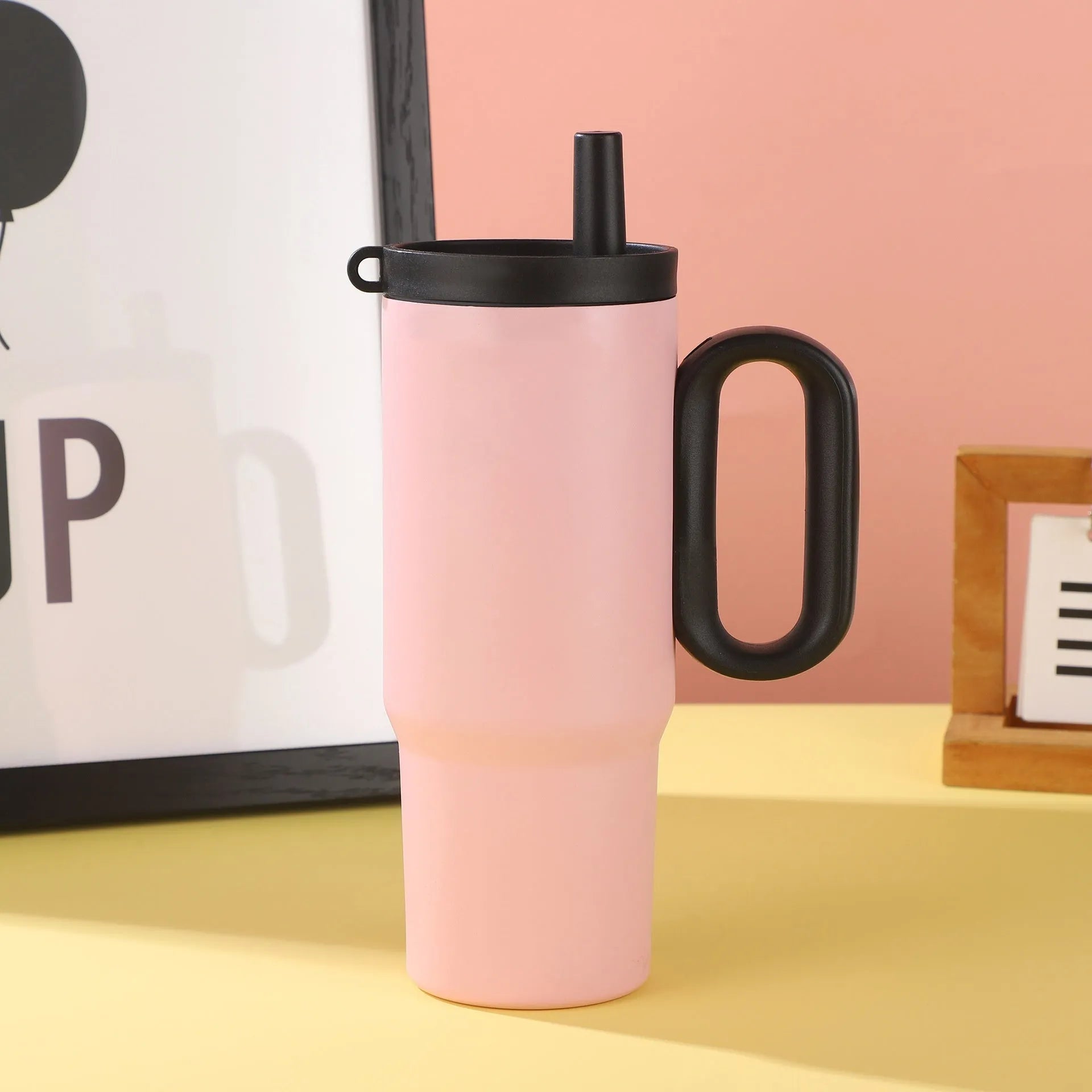 Large insulated straw drinking cup with a carrying handle in various colours.
