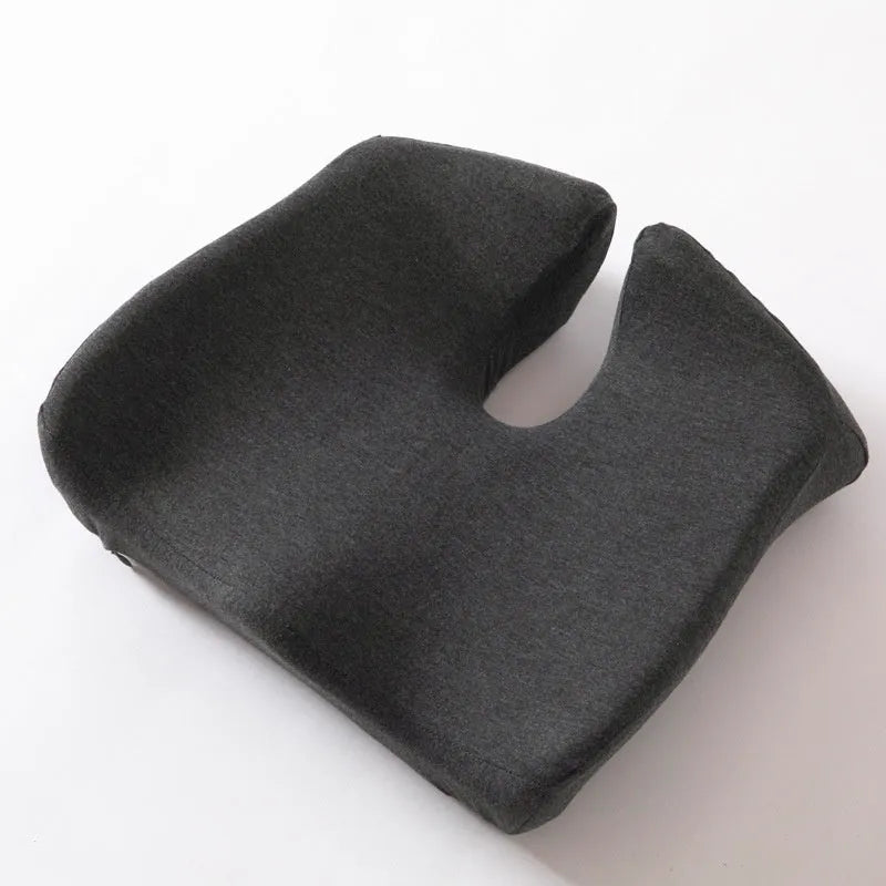 Dark grey memory foam office chair cushion for waist support, shown on a desk chair.