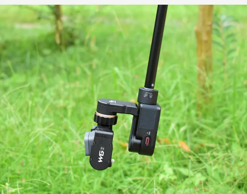 Black retractable selfie stick with Bluetooth remote, extended to full length with a smartphone attached.