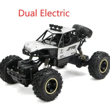 Large black or silver 4WD remote control climbing car on off-road terrain with wireless remote.