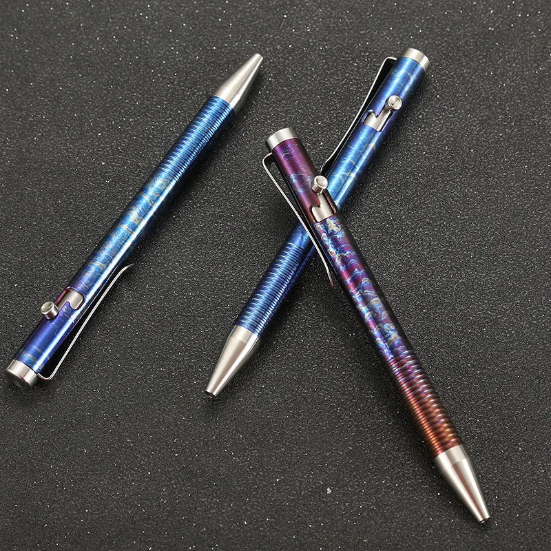 Titanium alloy gun bolt handle ball pen with a randomised phantom colour finish on a dark background.
