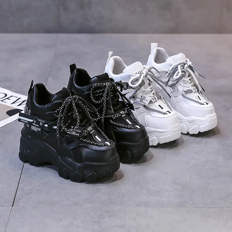 Women's white and black mesh platform sports shoes with cross-strap and rubber sole.