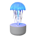 White jellyfish-shaped humidifier and essential oil diffuser with colourful LED lights on a desktop