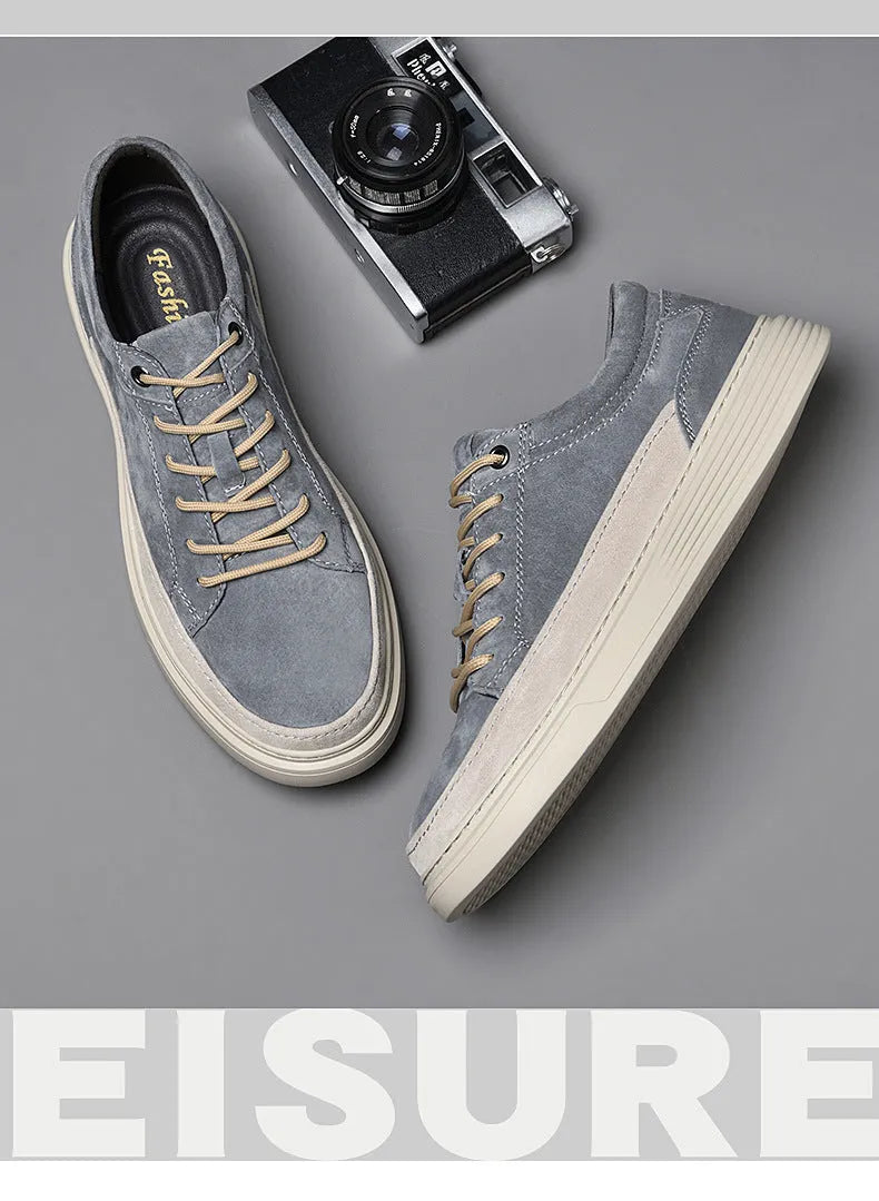 Men's grey low-top pigskin leather skate shoes with flat rubber sole and lace-up front.