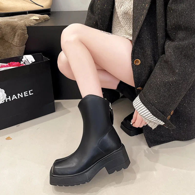 Black platform Martin boots for women with square toe, high heel, and back zip on a white background.