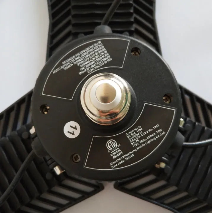 A foldable industrial LED garage flood light with a die-cast aluminum body, shown in a workshop setting.