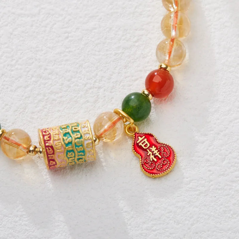 Close-up of a hand-woven citrine five sutra bracelet with 6mm geometric beads on a wrist.