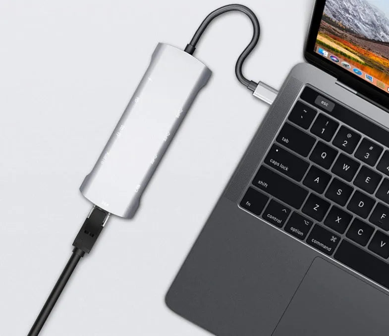 Grey aluminium USB-C docking station showing HDMI, VGA, USB 3.0, and power delivery ports