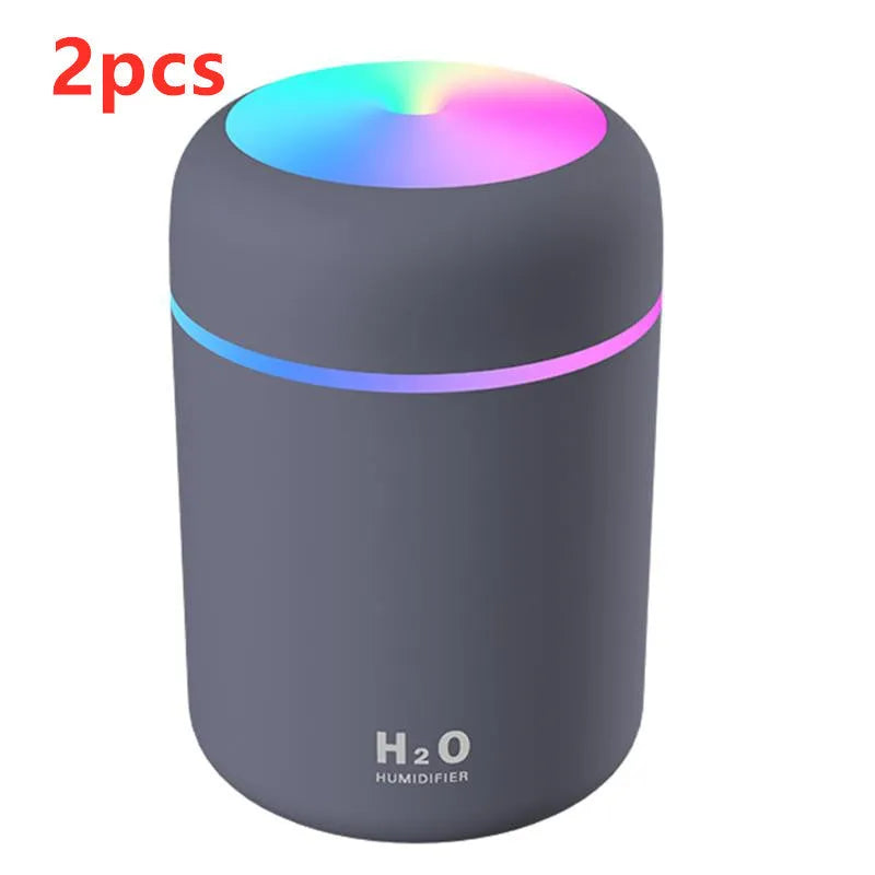 Pink USB portable humidifier with 300ml water tank on wooden desk surface