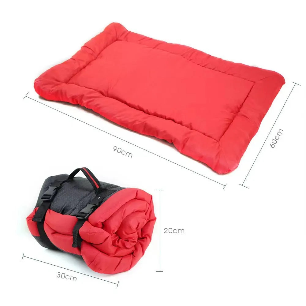 Blue folded portable dog bed with nylon buckles next to an unfolded bed on grass.