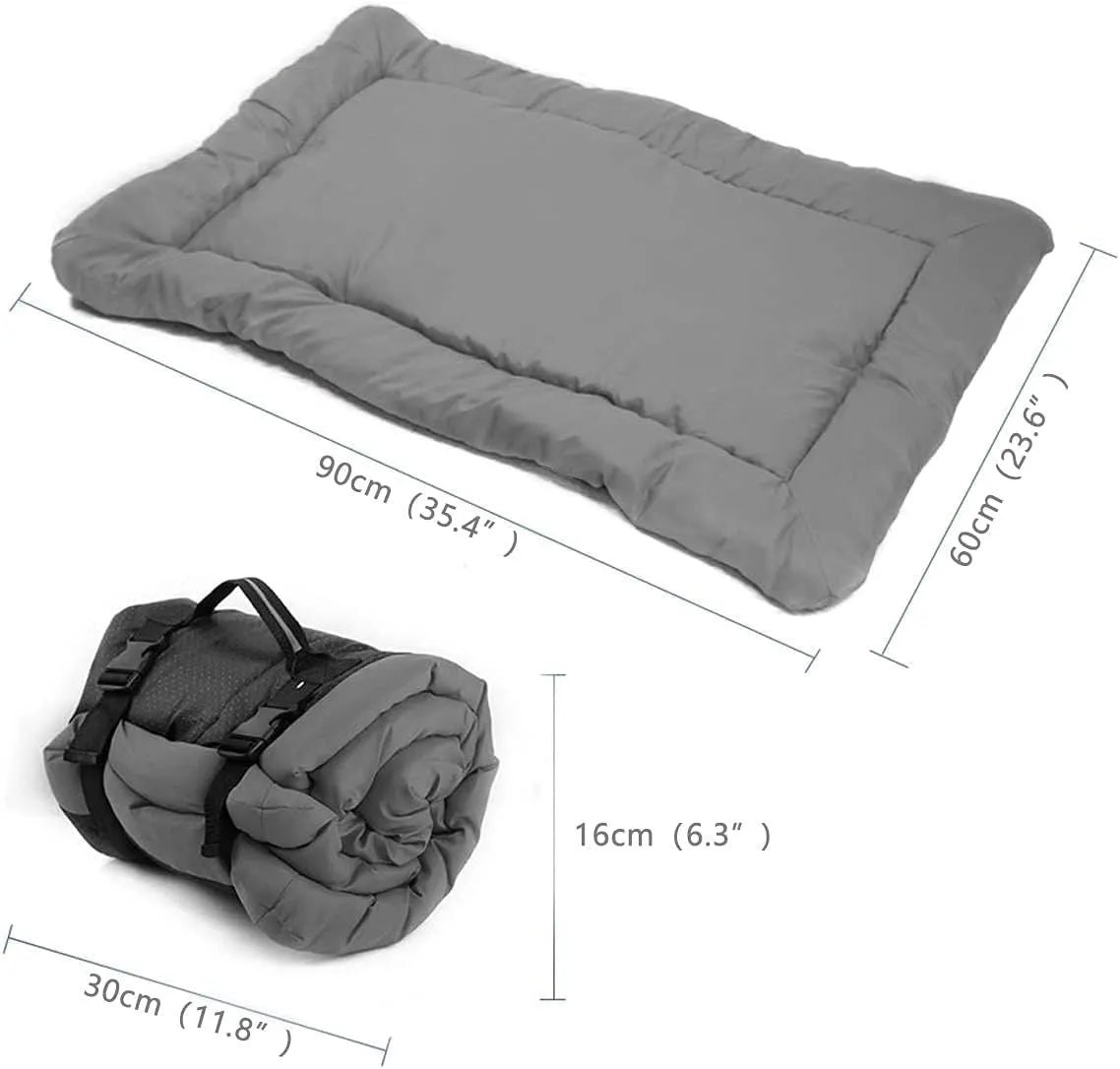 Blue folded portable dog bed with nylon buckles next to an unfolded bed on grass.