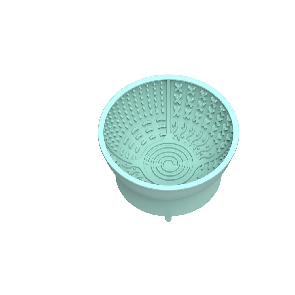 Cyan silicone slow feeding bowl for pets with suction cup base on a flat surface.