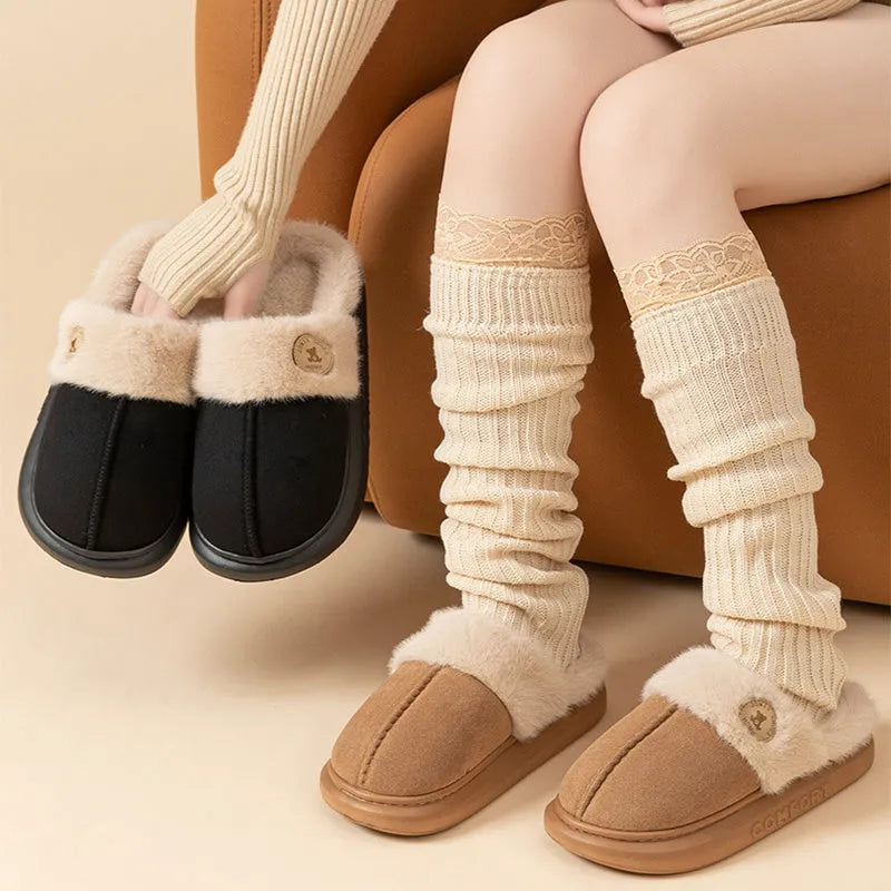 A pair of thick-soled plush fleece slippers in a chosen colour, showing decorative car stitching on the upper.