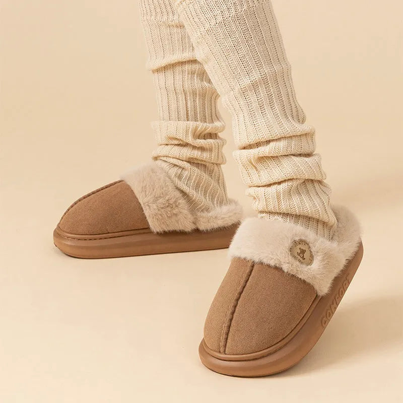 A pair of thick-soled plush fleece slippers in a chosen colour, showing decorative car stitching on the upper.