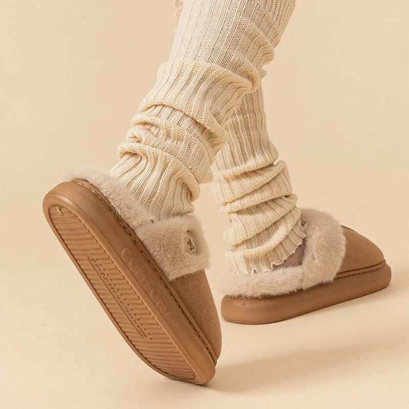 A pair of thick-soled plush fleece slippers in a chosen colour, showing decorative car stitching on the upper.
