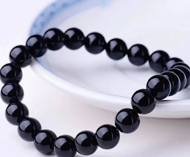 Geometric black onyx bracelet with 8mm beads on a black elastic cord.