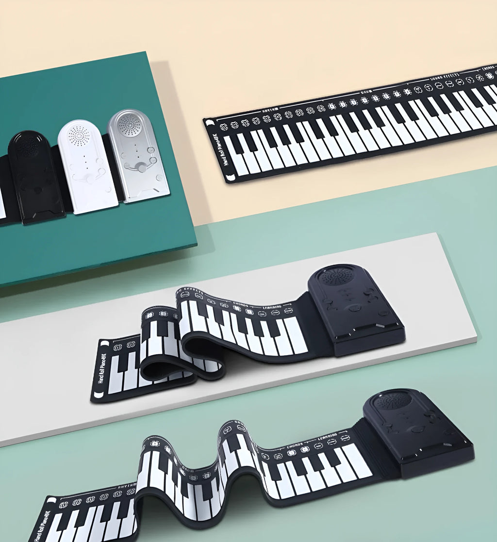 Rolled-up silicone keyboard next to black ABS control unit and speaker for portable 49-key electronic piano.