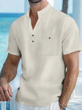 Man wearing a light blue linen-blend stand collar T-shirt with short sleeves and a loose fit.