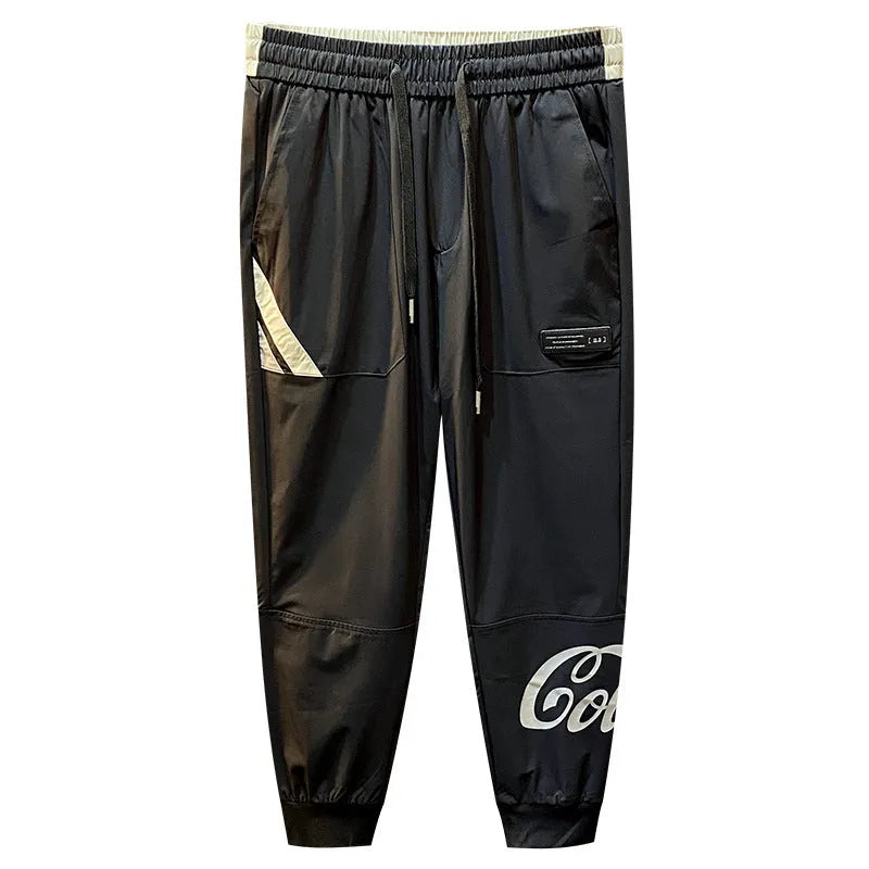 Man wearing black cropped cotton trousers with an ankle banded cuff.