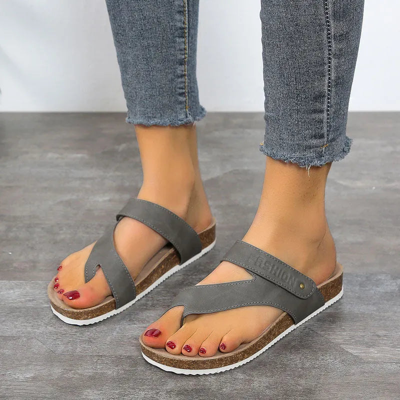 A pair of flat toe ring thick-soled flip-flops in a solid colour on a plain background.