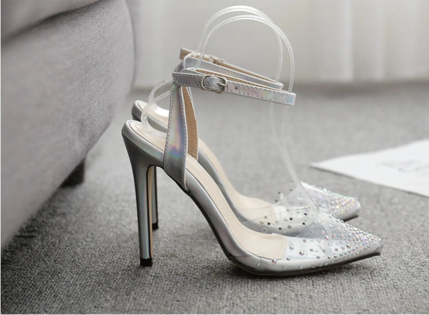 Women's clear PVC pointed toe sandals with a stiletto heel on a white background.