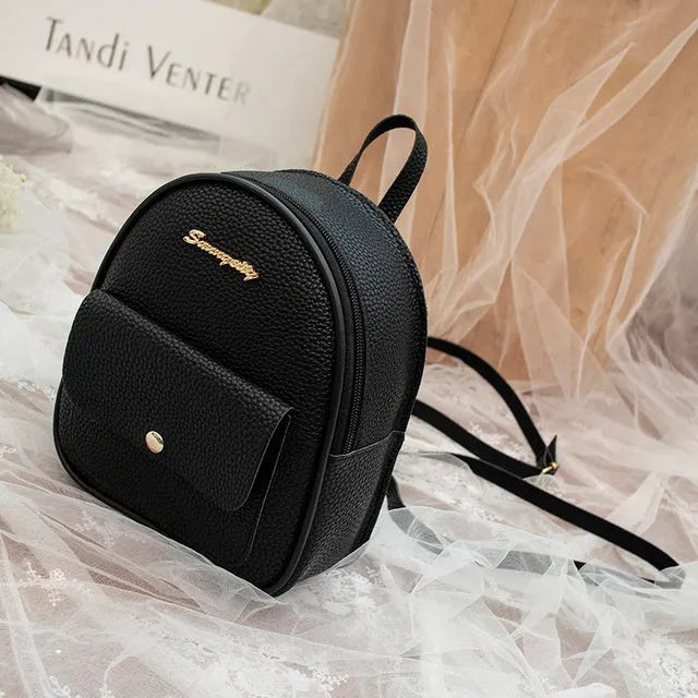 Compact black PU leather women's shoulder bag with zipper, shown next to a mobile phone for scale.