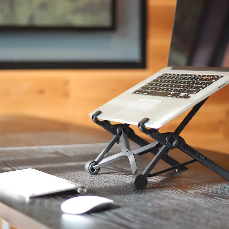 Black folding laptop stand made of reinforced nylon, shown in a compact folded size.