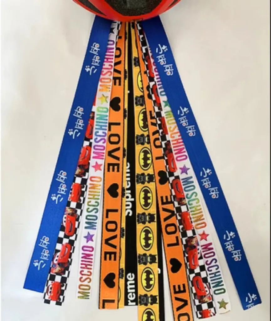 Close-up of a colourful decorative ribbon streamer attached to a child's helmet for roller skating or skiing.