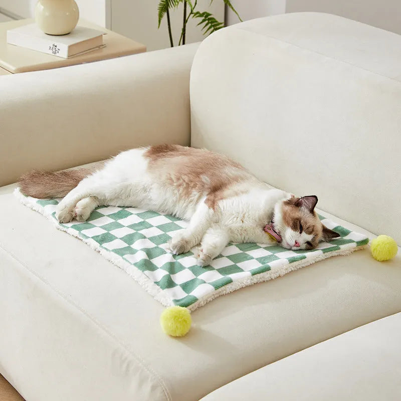 Green plaid pattern pet blanket with soft fleece texture on sofa