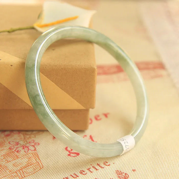 Green jade waxy geometric bracelet with unisex Chinese style design on a wrist.