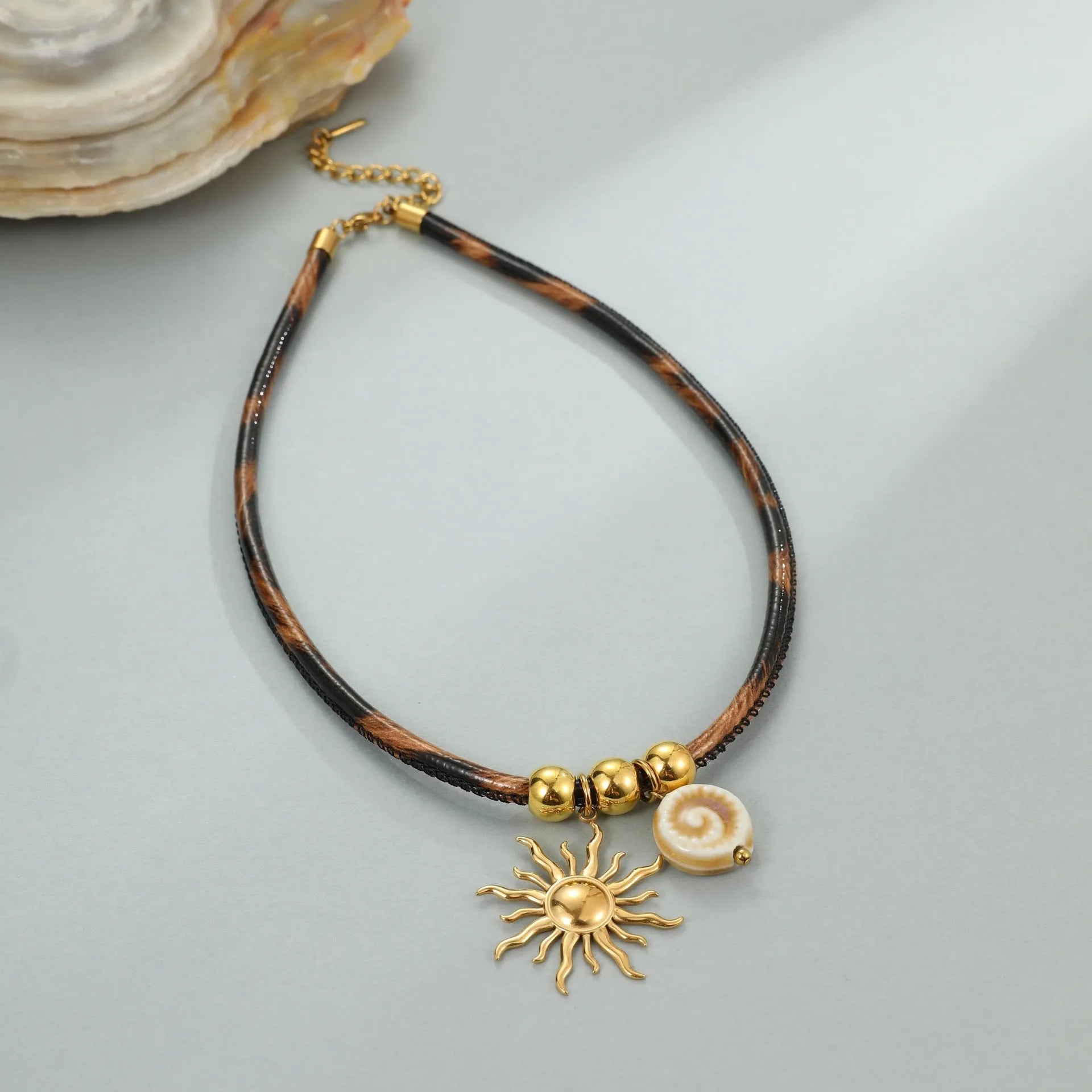 Geometric leopard print pendant on a gold-toned stainless steel necklace for women.