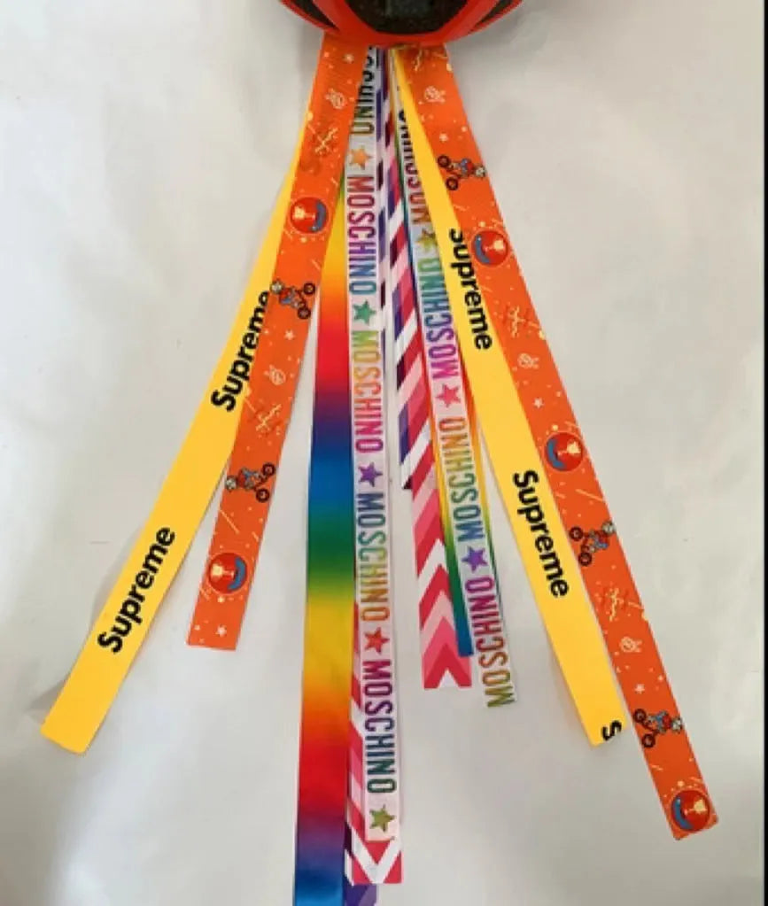 Close-up of a colourful decorative ribbon streamer attached to a child's helmet for roller skating or skiing.