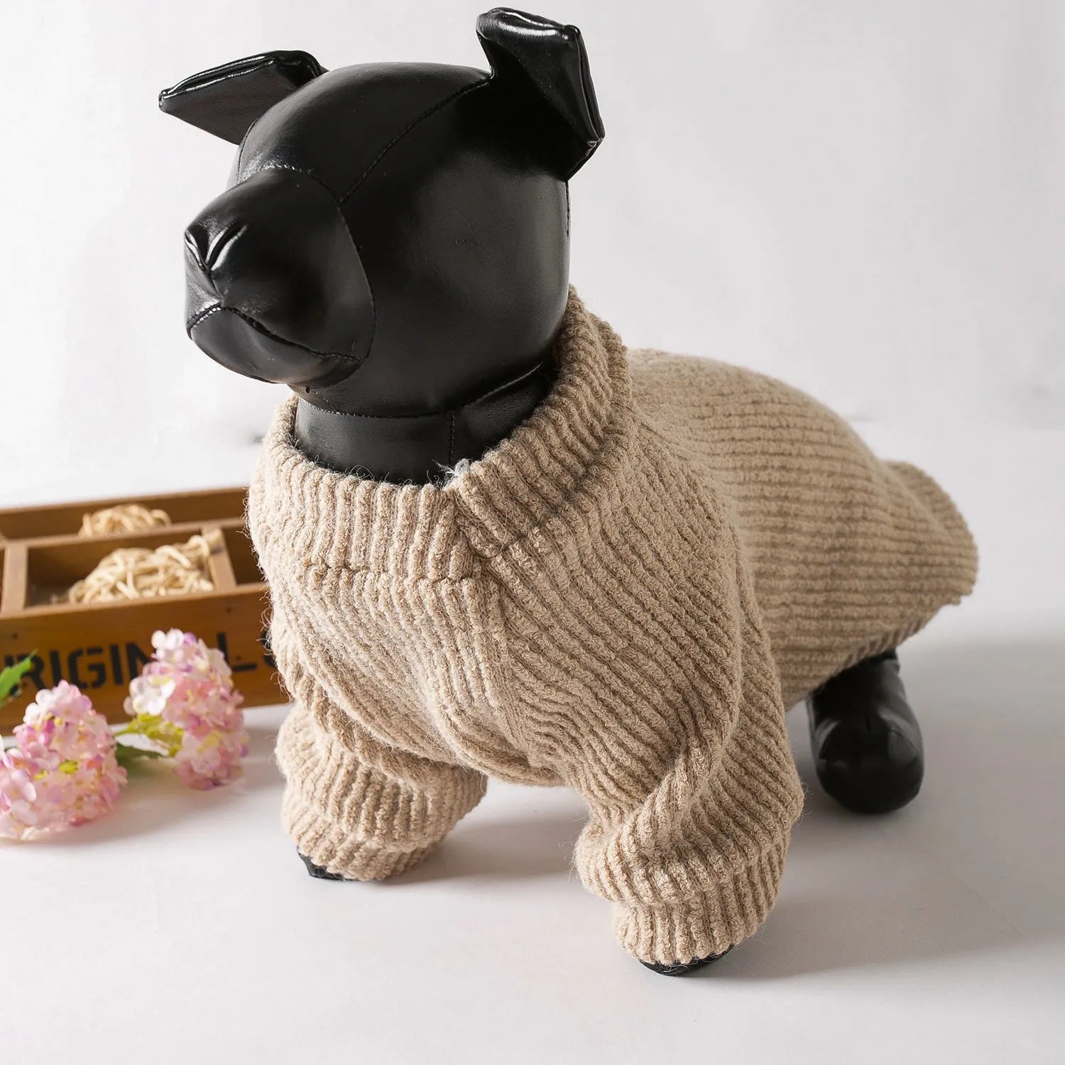 Brown knitted pullover sweater on a small dog, showing four-leg design for full coverage.