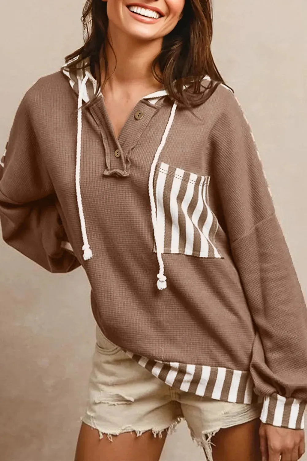 Straw yellow hoodie with waffle texture fabric, striped patchwork panels, button neck, and drawstring waist.