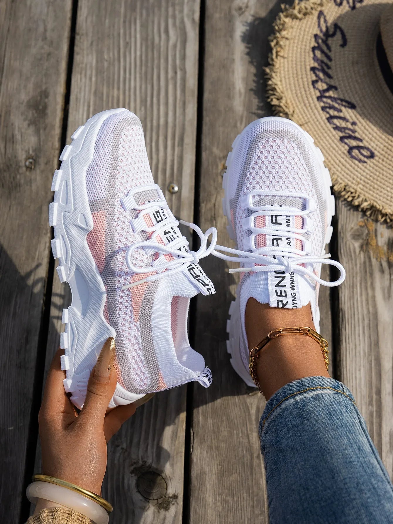 Women's Flyknit mesh sneakers in grey and white colour with flat rubber sole and lace-up front.
