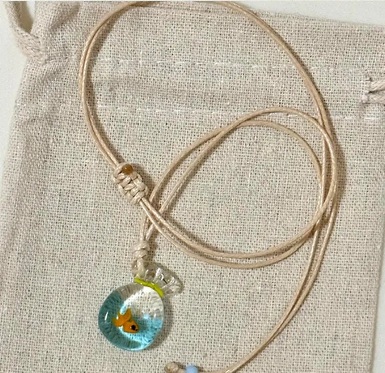 Women's necklace with a coloured glaze skirted joker pendant on a cotton and linen clavicle chain.
