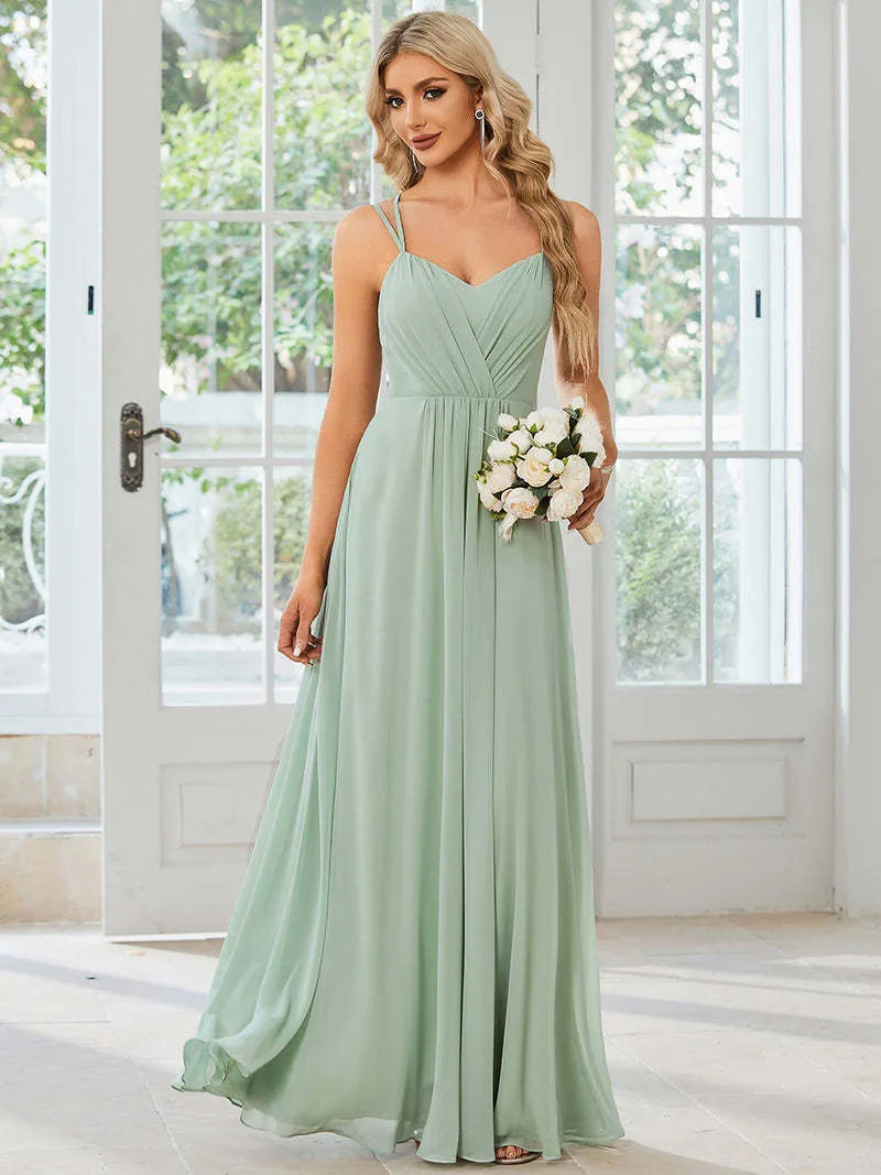 Women's light green sleeveless dress with sling neckline and long pleated A-line skirt.