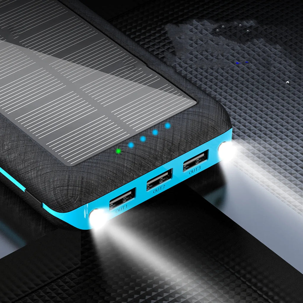Black portable power bank with wireless charging pad on top, three USB ports, and an LED flashlight.